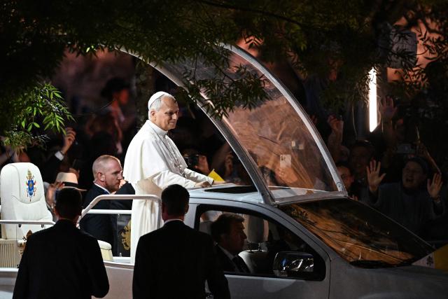 Pope Leo XIV stands on the Papamobile (popemobile) on his way to the Grotto of Apparitions at Massabielle in the Sanctuary of Our Lady of Lourdes, southwestern France, on September 26, 2026 on the second day of his visit to France. (Photo by Lionel BONAVENTURE / AFP)