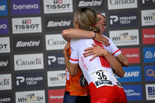 First-placed Demi Vollering of the Netherlands and runner-up Katarzyna Niewiadoma of Poland embrace on thhe podium after the Women's Elite Road Race at the 2026 Union Cycliste Internationale (UCI) Road World Championships in Montreal, Quebec, on September 26, 2026. (Photo by Andrej Ivanov / AFP)