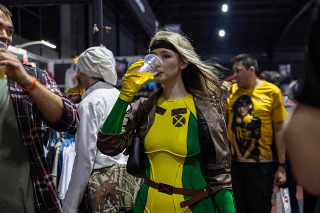 A cosplayer enjoys a drink as attendees visit exhibitor stands during Comic Con Africa, one of Africa's largest pop culture, fantasy and gaming festivals, at the Johannesburg Expo Centre in Johannesburg on September 26, 2026. Comic Con Africa is a pop culture and gaming convention that brings together fans of comics, films, television, gaming, cosplay and related entertainment, attracting exhibitors, creators and enthusiasts from across Africa and beyond. (Photo by Cecilia Seregni / AFP)