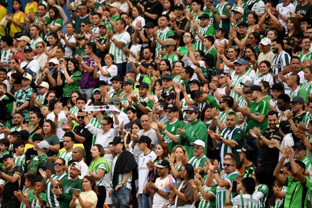 Fans of Atletico NAcional applaud to Chapecoense's players ahead of a friendly football match between Colombia's Atletico Nacional and Brazil's Chapecoense ahead of the tenth anniversary of the accident, at the Atanasio Girardot Stadium in Medellin, Colombia, on September 26, 2026. On November 28, 2016 the plane flying Chapecoense to Medellin to take on Atletico Nacional in the Copa Sudamericana finals -- the biggest and most unexpected game in the Brazilian team's history- ran out of fuel and went down in the mountains near its destination, killing 71 of the 77 aboard, including 19 players. (Photo by Jaime SALDARRIAGA / AFP)