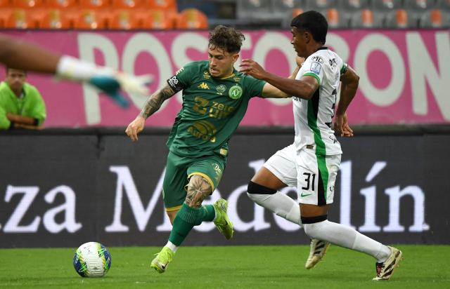 Chapecoense's forward #70 Rubens and Atletico Nacional's defender #31 Xavi Rios fight for the ball during a friendly football match between Colombia's Atletico Nacional and Brazil's Chapecoense ahead of the tenth anniversary of the accident, at the Atanasio Girardot Stadium in Medellin, Colombia, on September 26, 2026. On November 28, 2016 the plane flying Chapecoense to Medellin to take on Atletico Nacional in the Copa Sudamericana finals -- the biggest and most unexpected game in the Brazilian team's history- ran out of fuel and went down in the mountains near its destination, killing 71 of the 77 aboard, including 19 players. (Photo by Jaime SALDARRIAGA / AFP)