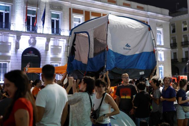 Demonstrators install tents as they camp during a protest against evictions and the housing crisis in front of the Presidency of the Community of Madrid on the Puerta del Sol plaza in Madrid on September 26, 2026. The sign reads: 'accessible housing'. Spain's main tenants' unions on September 25 urged the government to pass a new law to tackle the country's housing crisis after an 87-year-old was evicted from her Madrid home, sparking nationwide protests. (Photo by Oscar DEL POZO / AFP)