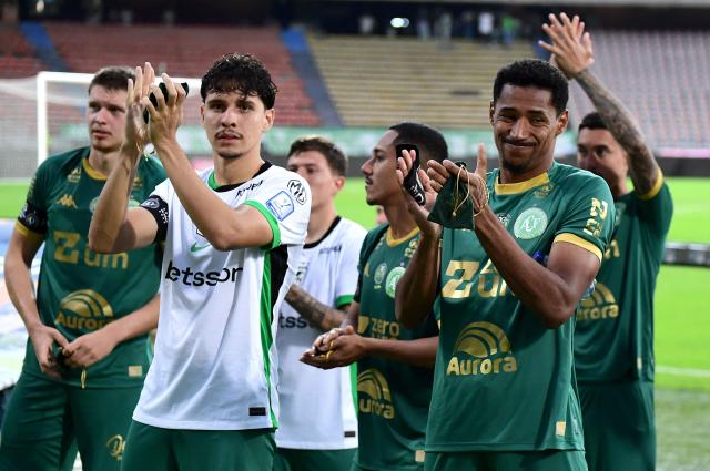 Chapecoense players acknowkledge the crowd after a friendly football match between Colombia's Atletico Nacional and Brazil's Chapecoense ahead of the tenth anniversary of the accident, at the Atanasio Girardot Stadium in Medellin, Colombia, on September 26, 2026. On November 28, 2016 the plane flying Chapecoense to Medellin to take on Atletico Nacional in the Copa Sudamericana finals -- the biggest and most unexpected game in the Brazilian team's history- ran out of fuel and went down in the mountains near its destination, killing 71 of the 77 aboard, including 19 players. (Photo by Jaime SALDARRIAGA / AFP)