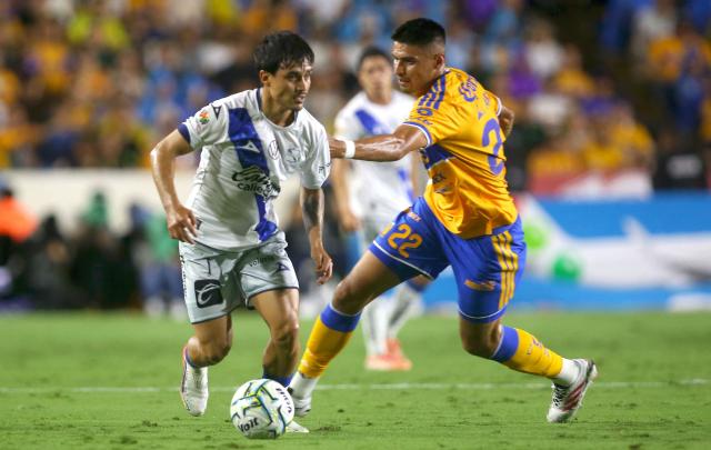 Puebla's defender #07 Fernando Monarrez and Tigres' forward #22 Guillermo Martinez fight for the ball during the Liga MX Apertura football match between Tigres and Puebla at the Universitario Stadium in San Nicolas de los Garza, Mexico on September 26, 2026. (Photo by Julio Cesar AGUILAR / AFP)