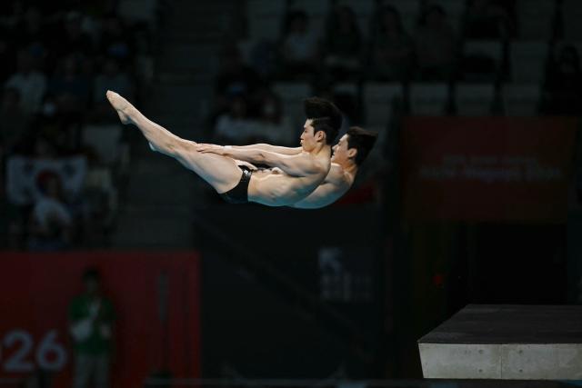 South Korea's Shin Jung-whi and Kim Yeong-taek compete in the men's synchronised 10m platform final diving event during the 2026 Asian Games at the Tokyo Aquatics Centre in Tokyo on September 27, 2026. (Photo by ANDREW CABALLERO-REYNOLDS / AFP)