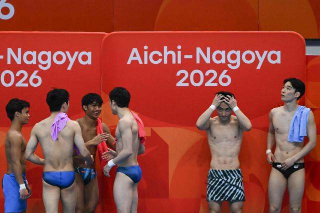 Gold medallists China's Yang Hao and Lian (in blue trunks, back facing camera) talk to silver medallists Malaysia's Enrique Harold and Elvis Priestly Clement while South Korea's Shin Jung-whi and Kim Yeong-taek (R) look on after competing in the men's synchronised 10m platform final diving event during the 2026 Asian Games at the Tokyo Aquatics Centre in Tokyo on September 27, 2026. (Photo by ANDREW CABALLERO-REYNOLDS / AFP)