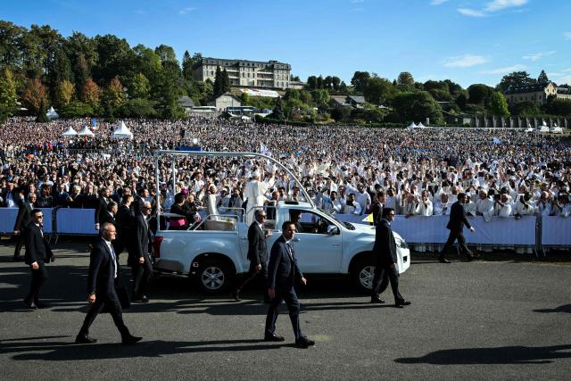 Pope Leo XIV waves to worshippers as he arrives on board of the Papamobile (popemobile) to celebrate a holy mass at the Prairie of the Shrine of Our Lady of Lourdes, southwestern France, on September 27, 2026 on the third day of his visit to France. (Photo by Alberto PIZZOLI / AFP)
