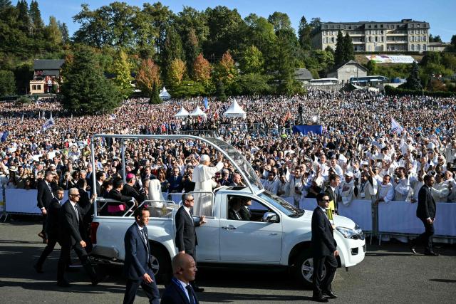 Pope Leo XIV waves to worshippers as he arrives on board of the Papamobile (popemobile) to celebrate a holy mass at the Prairie of the Shrine of Our Lady of Lourdes, southwestern France, on September 27, 2026 on the third day of his visit to France. (Photo by Alberto PIZZOLI / AFP)