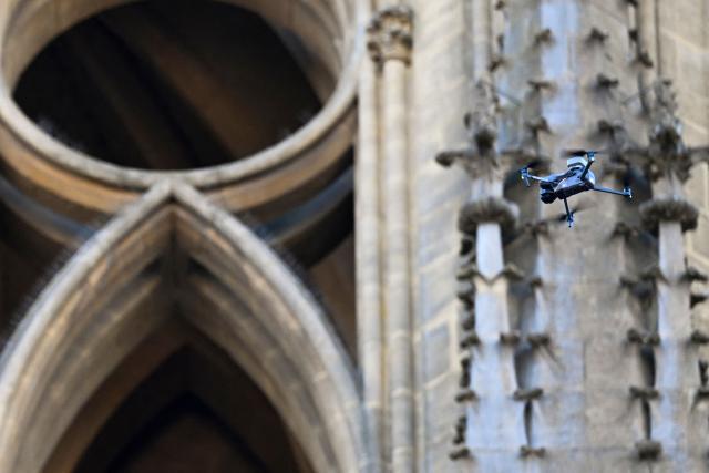 A drone (R) operated by a bomb disposal expert of France's civil Protection (Securite Civile) flies by the Gothic tracery the Saint-Etienne cathedral while carrying out a security sweep as part of the implementation of security measures on the eve of the Pope's visit on the last day of his official trip to France, on September 27, 2026. For the last leg of his trip, in Metz on September 28, Pope Leo XIV is set to deliver a speech about peace in Europe. (Photo by Jean-Christophe VERHAEGEN / POOL / AFP)