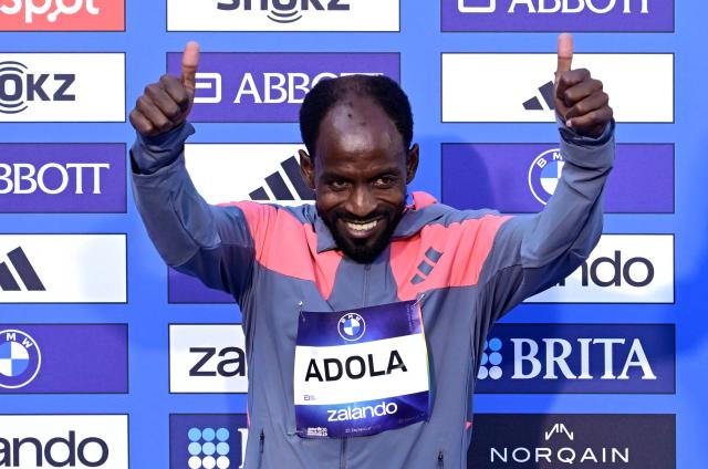 Ethiopia's Guye Adola celebrates on the podium after winning the 52nd edition of the Berlin Marathon in Berlin, Germany on September 27, 2026. (Photo by John MACDOUGALL / AFP)