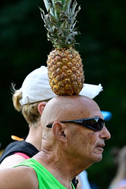 Israeli marathon runner Moshe Lederfien balances a pineapple on his head as he competes in the 52nd edition of the Berlin Marathon in Berlin, Germany on September 27, 2026. (Photo by John MACDOUGALL / AFP)