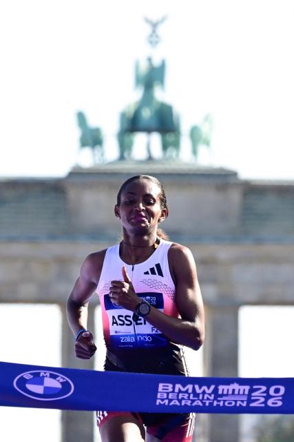 Ethiopia's Tigst Assefa crosses the finish line to win the women's race of 52nd Berlin Marathon in Berlin, Germany on September 27, 2026. Ethiopian runner Tigst Assefa narrowly missed out on breaking the women's world record at the Berlin Marathon on Sunday, crossing the finish line with an injury after being on record pace throughout. (Photo by John MACDOUGALL / AFP)