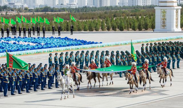 Participants appear with a Turkmen national flag during a parade marking the 35th anniversary of Turkmenistan's independence in central Ashgabat on September 27, 2026. (Photo by Nikolay VAVILOV / AFP)
