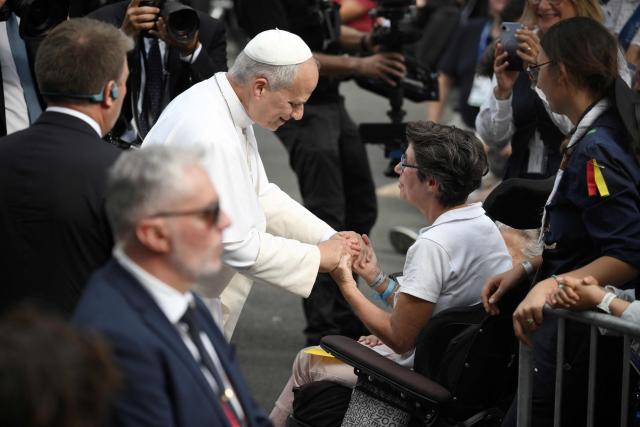 Pope Leo XIV cheers a woman on a wheelchair during his meeting with support workers and service users of the structure Accueil Notre-Dame at the Shrine of our Lady of Lourdes, during his visit in Lourdes southwestern France, on September 27, 2026 on the third day of his trip to France. (Photo by Ed JONES / AFP)