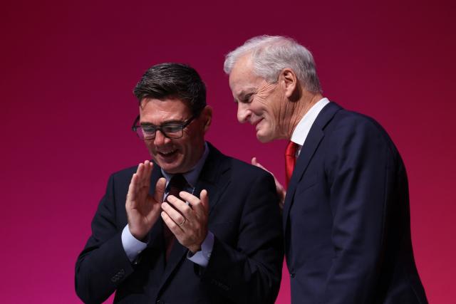 Norway's Prime Minister Jonas Gahr Store (R) is applauded by Britain's Prime Minister Andy Burnham (L) on stage on the first day of the annual Labour Party conference in Liverpool, north-west England, on September 27, 2026. Britain's ruling Labour Party gathers Sunday for its first annual conference under Andy Burnham's leadership, heartened by his start as prime minister but now looking for concrete plans to tackle looming challenges. (Photo by Darren Staples / AFP)