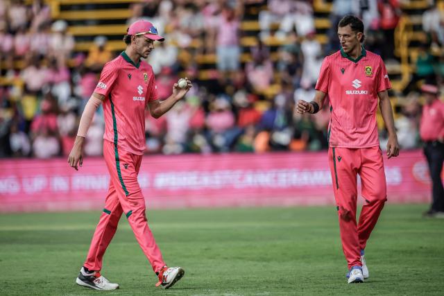 South Africa's Marco Jansen (L) hands the ball to his teammate and brother Duan Jansen (R) as Duan prepares to bowl during the second one-day international (ODI) cricket match between South Africa and Australia at the DP World Wanderers Stadium in Johannesburg on September 27, 2026. (Photo by PHILL MAGAKOE / AFP)