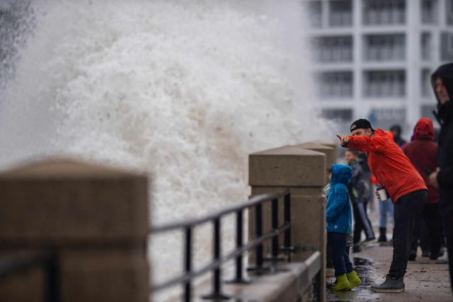 Onlookers watch waves crash onto the shore during a noreaster storm in Hampton, New Hampshire, on September 27, 2026. A powerful autumnal storm lashed the heavily populated US Northeast corridor with wind, rain and large waves, knocking out power for thousands and killing at least one person. Nor'easters, as storms like these are known, can cause billions of dollars in damage as they bring torrential rain, sometimes snow, strong winds and heavy storm surge flooding to large swaths of the US East Coast. The National Weather Service (NWS) said Sunday morning that the storm was "slowly weakening" after causing days of havoc up and down the East Coast. (Photo by Joseph Prezioso / AFP)
