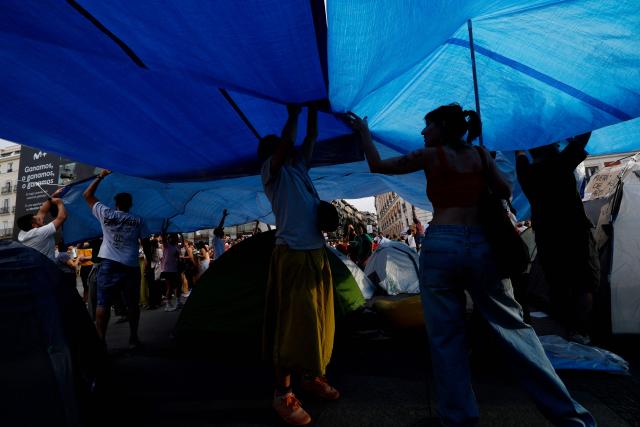 Demonstrators camp with tents to protest against evictions and the housing crisis in front of the Presidency of the Community of Madrid on the Puerta del Sol plaza in Madrid on September 27, 2026. Signs read 'Vulture funds out you go' and 'Evict a pensioner is shameful'. Spain's main tenants' unions on September 25 urged the government to pass a new law to tackle the country's housing crisis after an 87-year-old was evicted from her Madrid home, sparking nationwide protests. (Photo by Oscar DEL POZO / AFP)