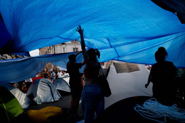 Demonstrators camp with tents to protest against evictions and the housing crisis in front of the Presidency of the Community of Madrid on the Puerta del Sol plaza in Madrid on September 27, 2026. Signs read 'Vulture funds out you go' and 'Evict a pensioner is shameful'. Spain's main tenants' unions on September 25 urged the government to pass a new law to tackle the country's housing crisis after an 87-year-old was evicted from her Madrid home, sparking nationwide protests. (Photo by Oscar DEL POZO / AFP)
