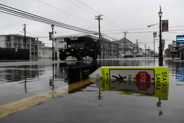 A police vehicle drives through a flooded street in Sea Isle, New Jersey, on September 27, 2026. A powerful autumnal storm lashed the heavily populated US Northeast corridor with wind, rain and large waves, knocking out power for thousands and killing at least one person. Nor'easters, as storms like these are known, can cause billions of dollars in damage as they bring torrential rain, sometimes snow, strong winds and heavy storm surge flooding to large swaths of the US East Coast. The National Weather Service (NWS) said Sunday morning that the storm was "slowly weakening" after causing days of havoc up and down the East Coast. (Photo by Matthew HATCHER / AFP)