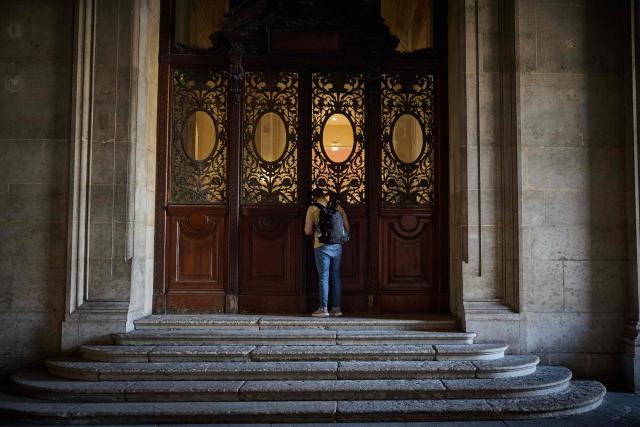 A visitor pears into the Louvre Museum from the Richelieu Passage on World Tourism Day in Paris on September 27, 2026. The Louvre remained the world’s most visited museum in 2025, welcoming more than nine million visitors. (Photo by Kiran RIDLEY / AFP)