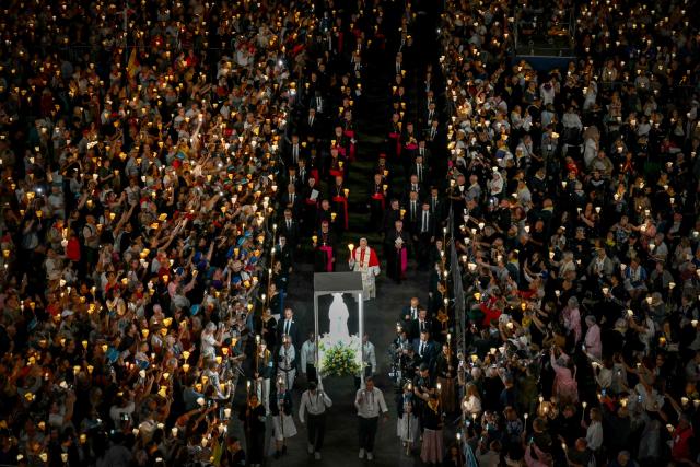 Pope Leo XIV (C) takes part in a torchlight procession following the Rosary Prayer at the Shrine of Our Lady of Lourdes, southwestern France, on September 27, 2026 on the third day of his visit to France. (Photo by Alberto PIZZOLI / AFP)