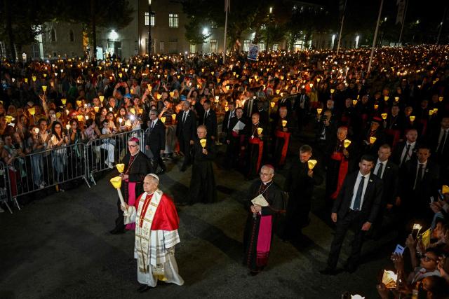 Pope Leo XIV (L) takes part in a torchlight procession following the Rosary Prayer at the Shrine of Our Lady of Lourdes, southwestern France, on September 27, 2026 on the third day of his visit to France. (Photo by Lionel BONAVENTURE / AFP)