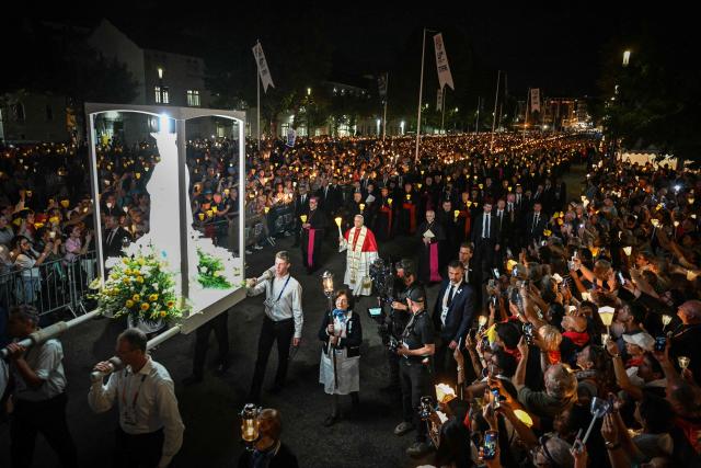 Pope Leo XIV (C) takes part in a torchlight procession following the Rosary Prayer at the Shrine of Our Lady of Lourdes, southwestern France, on September 27, 2026 on the third day of his visit to France. (Photo by Lionel BONAVENTURE / AFP)