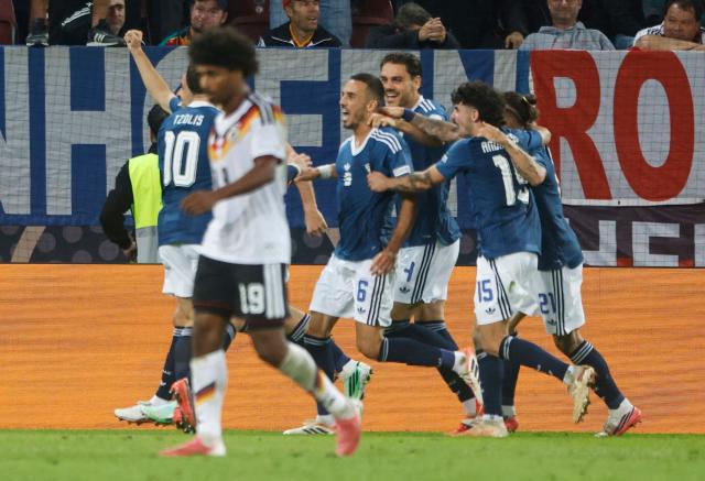 Greece's midfielder #06 Dimitrios Kourbelis (C) celebrates with teammates scoring the opening goal during the UEFA Nations League Group A2 between Germany and Greece in Augsburg, southern Germany on September 27, 2026. (Photo by Michaela STACHE / AFP)
