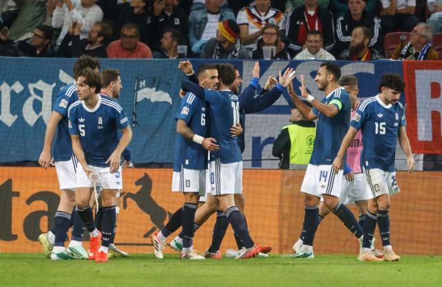 Greece's midfielder #06 Dimitrios Kourbelis (C) celebrates with teammates scoring the opening goal during the UEFA Nations League Group A2 between Germany and Greece in Augsburg, southern Germany on September 27, 2026. (Photo by Michaela STACHE / AFP)