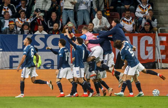 Greece's midfielder #06 Dimitrios Kourbelis (L) celebrates with teammates scoring the opening goal during the UEFA Nations League Group A2 between Germany and Greece in Augsburg, southern Germany on September 27, 2026. (Photo by Michaela STACHE / AFP)