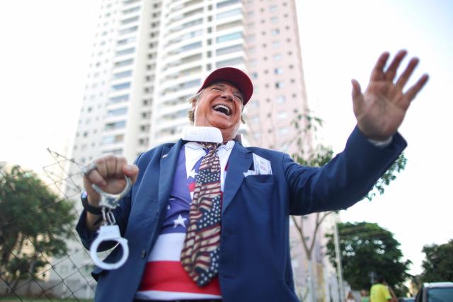 A man wearing a mask depicting US President Donald trump attends a rally of Brazilian right-wing presidential candidate Flavio Bolsonaro in Goiania, Brazil, on September 27, 2026. Brazil will hold presidential election on October 4, 2026. (Photo by Sergio Lima / AFP)