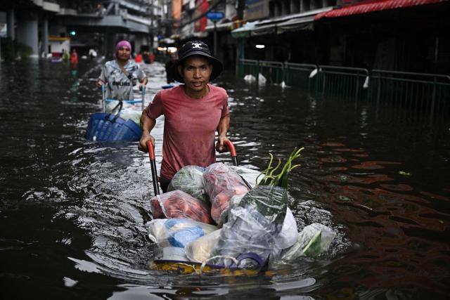 Vendors transport produce through floodwaters in Bang Kapi district in Bangkok on September 28, 2026. Eight people have died in flooding in Thailand since September 16, although none in the capital Bangkok which declared a disaster this weekend following heavy rains, the government said on September 28. (Photo by Lillian SUWANRUMPHA / AFP)