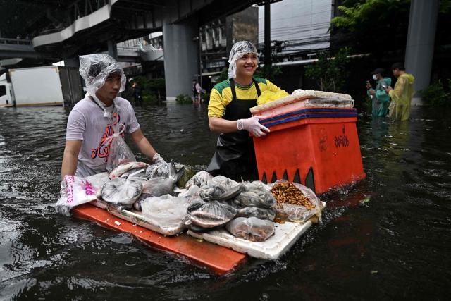Vendors transport produce through floodwaters in Bang Kapi district in Bangkok on September 28, 2026. Eight people have died in flooding in Thailand since September 16, although none in the capital Bangkok which declared a disaster this weekend following heavy rains, the government said on September 28. (Photo by Lillian SUWANRUMPHA / AFP)