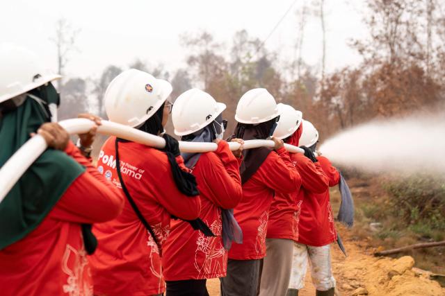 Members of the all-women The Power of Mama (TPoM) volunteer firefighting team spray water onto smouldering peatland in Mensubuk Lama, Tanjungpura Village, Ketapang Regency, West Kalimantan on September 26, 2026. Indonesia has been battling fires for weeks in parts of Borneo and Sumatra, sending suffocating haze across the islands and neighbouring Malaysia and Singapore. (Photo by HERIBERTUS / AFP)