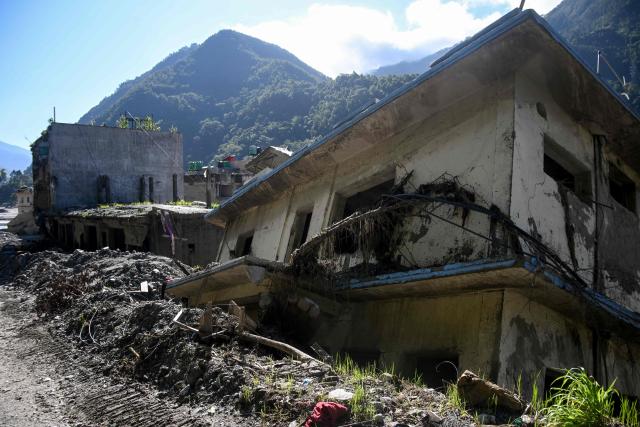 A general view shows damaged houses covered in sludge in the aftermath of the August 26 flash flood, at Betrawati Bazaar in Nepal's Rasuwa district on September 28, 2026. The Himalayan nation suffered one of the worst catastrophes in its history late last month when a tsunami-like flood, triggered by a high-altitude glacial mountain collapse along the Nepal-China border, cut a swathe of destruction claiming more than 1,400 lives and leaving 5,000 unaccounted for. (Photo by PRAKASH MATHEMA / AFP)