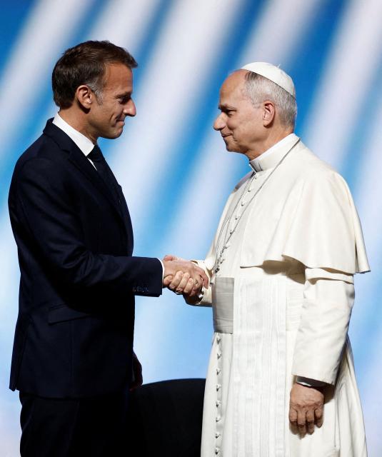 Pope Leo XIV (R) is welcomed by France's President Emmanuel Macron as he arrives on stage at the opening of a meeting called "At the Roots of Europe: For Peace and Unity" at the Robert Schuman Conference Centre in Metz, northeastern France, on September 28, 2026 on the last day of his visit to France. (Photo by Benoit Tessier / POOL / AFP)