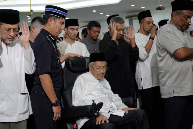 Former Malaysian prime minister Mahathir Mohamad (C) prays during the funeral of his wife, Siti Hasmah Mohamad Ali, at As Syarif Mosque in Kuala Lumpur on September 28, 2026. Hasmah, the wife of Malaysia's longest serving two-time prime minister Mahathir Mohamad, passed away September 28, 2026 aged 100. (Photo by Najjua Zulkefli / AFP)