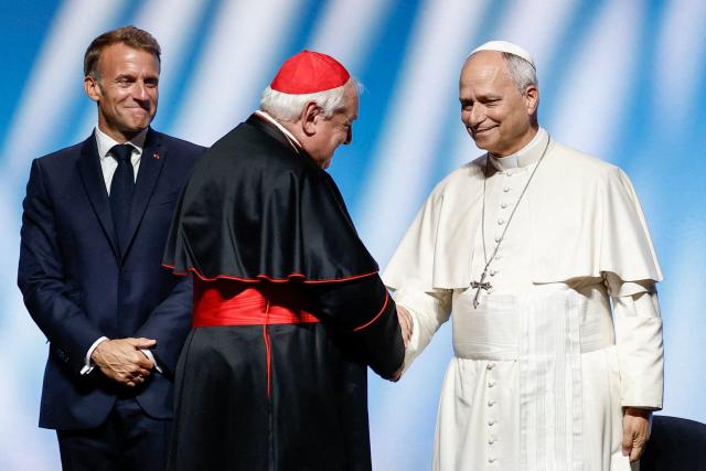 Pope Leo XIV (R) shakes hand with President of the Conference of Bishops of France Cardinal Jean-Marc Aveline (C) as France's President Emmanuel Macron (L) looks on during a meeting called "At the Roots of Europe: For Peace and Unity" at the Robert Schuman Conference Centre in Metz, northeastern France, on September 28, 2026 on the last day of his visit to France. (Photo by Benoit Tessier / POOL / AFP)