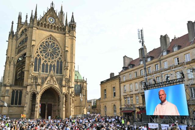 People listen to the Pope speech on a giant screen broadcasting a conference called "At the Roots of Europe: For Peace and Unity" as they wait outside the Saint-Etienne Cathedral in Metz, northeastern France, where the Pope will celebrate a mass later on September 28, 2026 on the last day of the Pope visit to France. (Photo by SEBASTIEN BOZON / AFP)