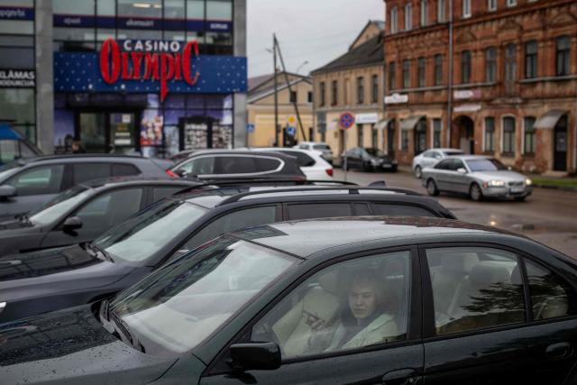 A man talks on his phone while sitting in his car outside the Olympic Casino in the centre of Daugavpils, Latvia, on September 26, 2026, ahead of the country's parliamentary elections on October 3. Latvia goes to the polls for parliamentary elections on October 3, 2026. (Photo by Wojtek RADWANSKI / AFP)