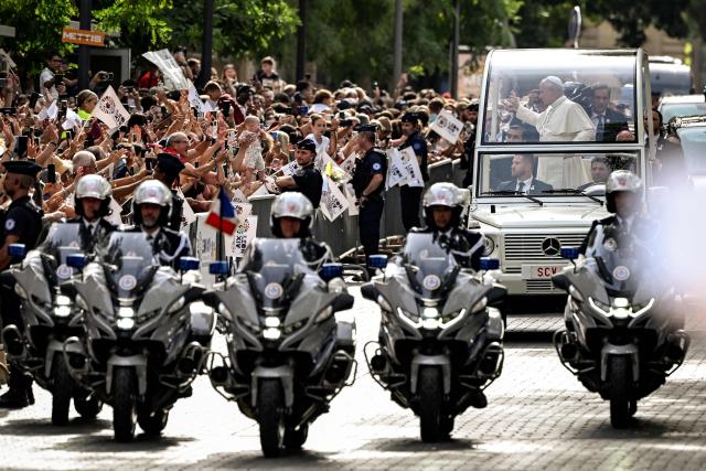 Pope Leo XIV waves to the crowd while riding in the Papamobile (popemobile) through the streets of Metz, northeastern France on September 28, 2026 on the last day of his visit to France. (Photo by Jean-Christophe VERHAEGEN / AFP)