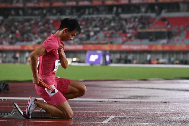 China's Chen Jinfeng prays before competing in the men's 4x100m relay final during the 2026 Asian Games at Nagoya City Mizuho Park Athletic Stadium in Nagoya, Aichi Prefecture on September 28, 2026. (Photo by MOHD RASFAN / AFP)