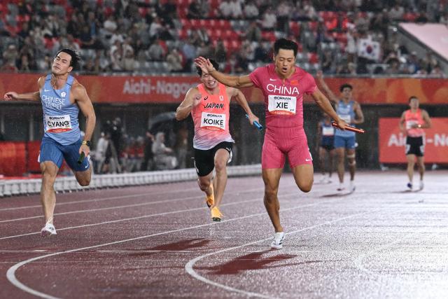 China's Xie Zhenye (R) crosses the finish line ahead of Japan's Yuki Koike (C) and Taiwan's Yang Chun-han to win the men's 4x100m relay final during the 2026 Asian Games at Nagoya City Mizuho Park Athletic Stadium in Nagoya, Aichi Prefecture on September 28, 2026. (Photo by MOHD RASFAN / AFP)