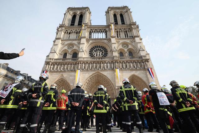 Firefighters observe a minute of silence in memory of their comrades killed while battling wildfires in France, in front of Notre-Dame de Paris Cathedral during a protest called by a broad coalition of unions campaigning for higher pay and increased budgetary resources, in Paris, on September 28, 2026. Professional firefighters, who are local government employees, together with around 200,000 volunteer firefighters, are calling for increased recruitment, stronger health protections, and a clearer focus on their core duties. (Photo by Xavier GALIANA / AFP)