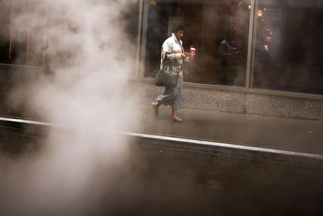 A man walks in a street as the rains pours in the Manhattan borough of New York City on September 28, 2026. (Photo by CHARLY TRIBALLEAU / AFP)