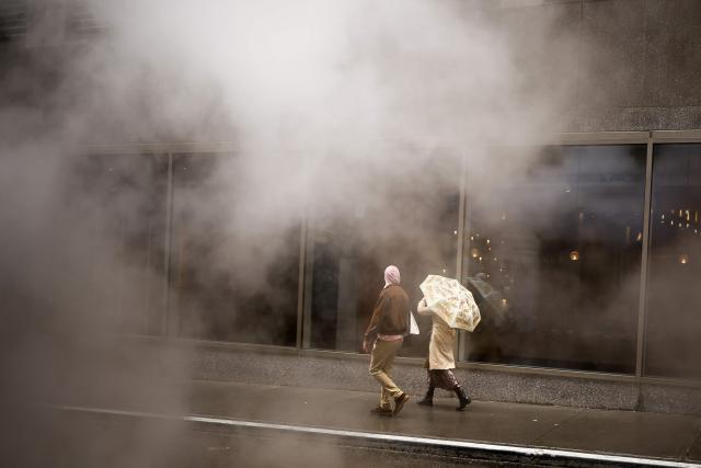 A man walks in a street as the rains pours in the Manhattan borough of New York City on September 28, 2026. (Photo by CHARLY TRIBALLEAU / AFP)