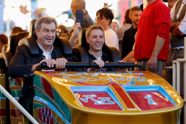 Bavaria's State Premier Markus Soeder (L) and mayor of Munich Dominik Krause (R) react after they rode a rollercoaster at Munich's annual beer festival, the Oktoberfest, on September 28, 2026 in Munich, southern Germany. The world's biggest beer festival Oktoberfest runs until October 4, 2026. (Photo by Michaela STACHE / AFP)