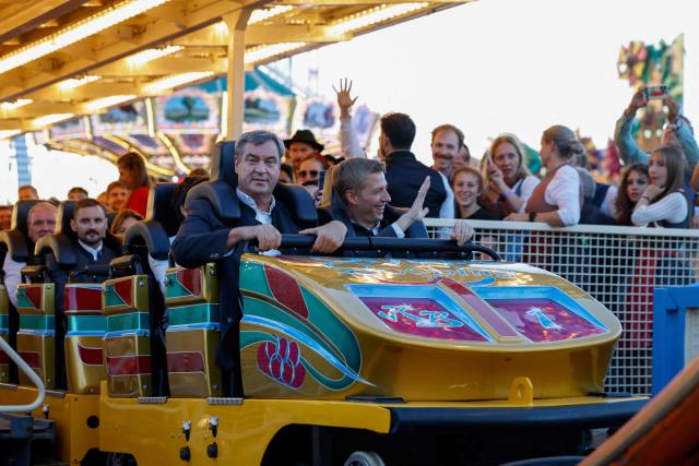 Bavaria's State Premier Markus Soeder (L) and mayor of Munich Dominik Krause (R) reacts after they rode a rollercoaster at Munich's annual beer festival, the Oktoberfest, on September 28, 2026 in Munich, southern Germany. The world's biggest beer festival Oktoberfest runs until October 4, 2026. (Photo by Michaela STACHE / AFP)