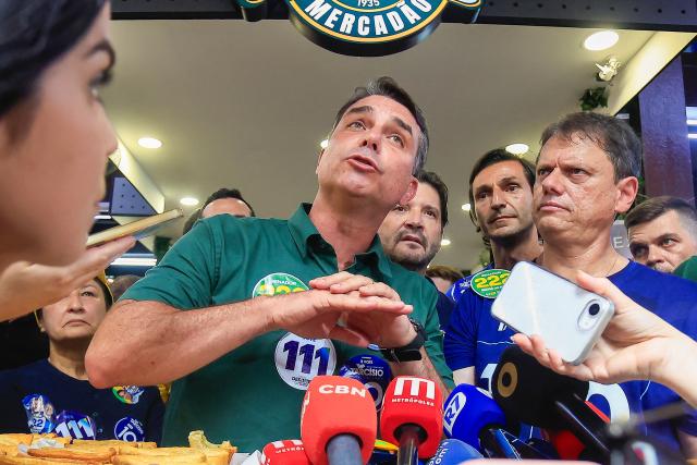 Brazil's right-wing senator and presidential candidate Flavio Bolsonaro (C), of the Liberal Party (PL), next to Sao Paulo's governor Tarcisio de Freitas speaks with the media during a campaign rally at the Sao Paulo Municipal Market in Sao Paulo, Brazil, on September 28, 2026. Brazil will hold presidential election on October 4, 2026. (Photo by Miguel SCHINCARIOL / AFP)